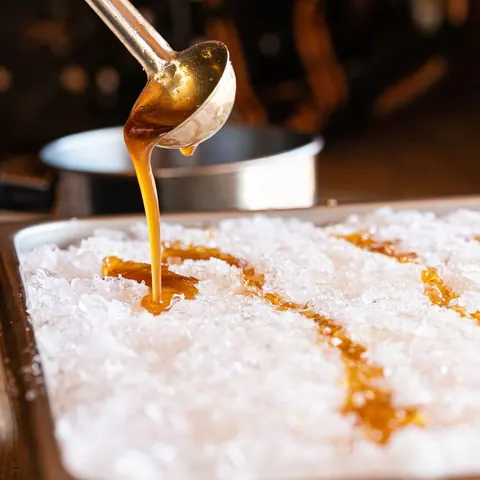Hot maple syrup poured onto snow to make maple taffy