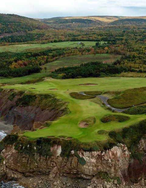Golf green at Highlands Links between forest and ocean