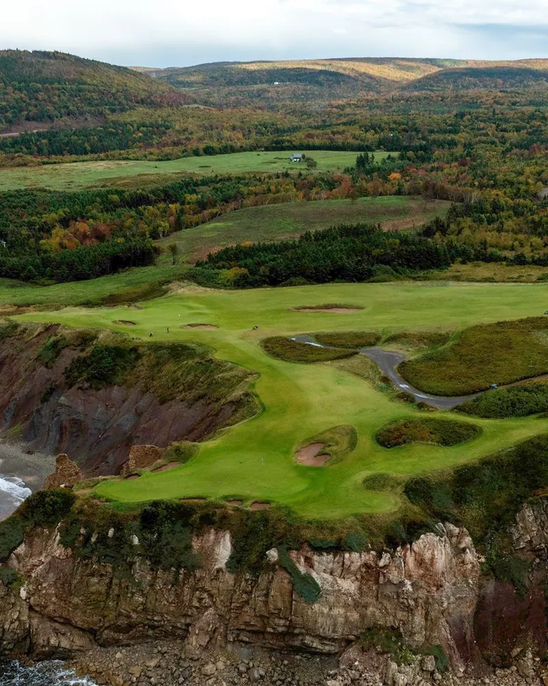 Golf green at Highlands Links between forest and ocean