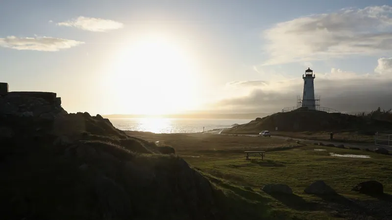 Lighthouse on a headland at sunset