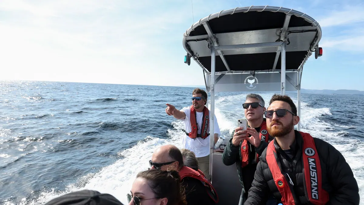 Guests in life jackets pointing out wildlife from a tour boat