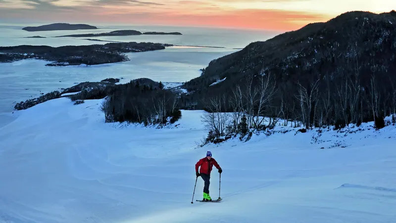 Snowshoer crossing a snowfield above a frozen bay