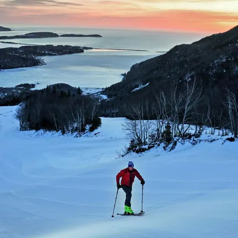 Snowshoer crossing a snowfield above a frozen bay