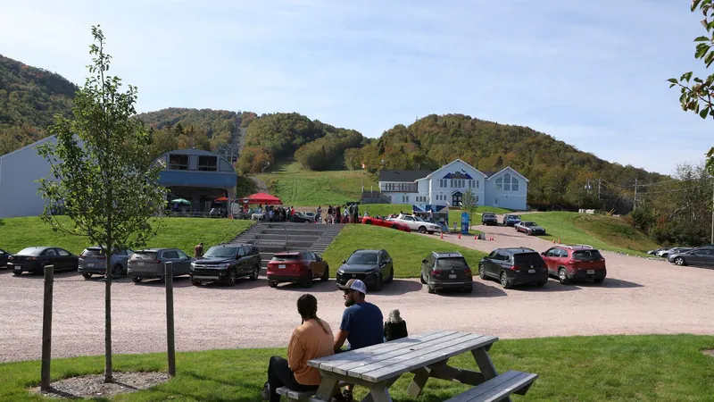 Guests relaxing at picnic tables by the Cape Smokey base lodge in summer