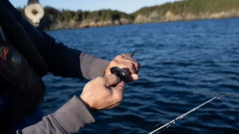 Close-up of hands reeling in a fishing line over the sea