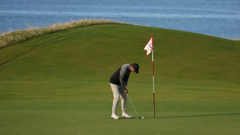 Golfer putting beside the flag on a green