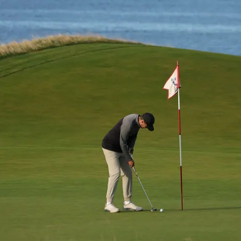 Golfer putting beside the flag on a green