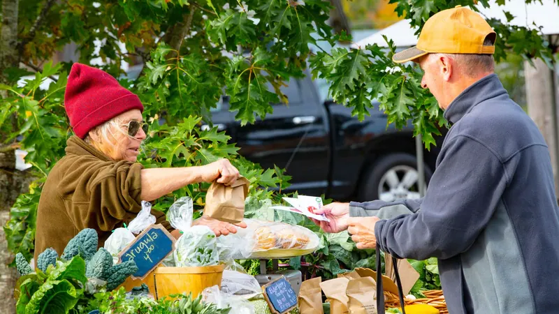 Vendor and customer at a farmers’ market stall