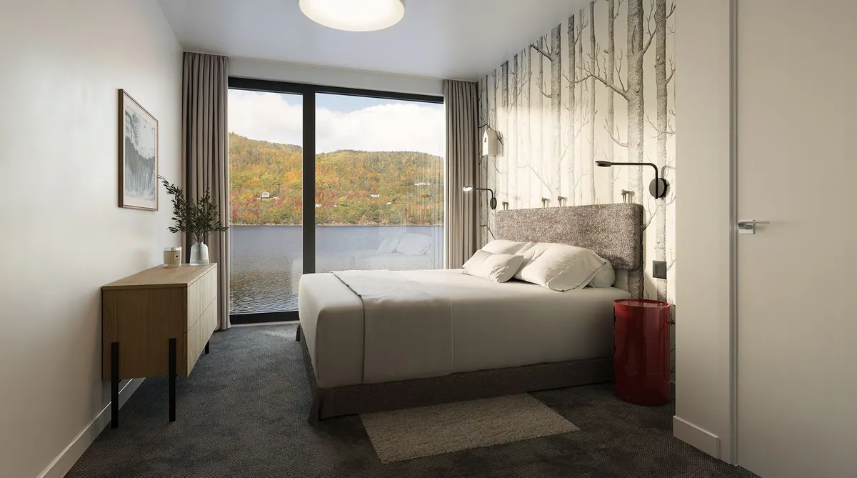 Bedroom with a birch-tree feature wall, king-size bed and a window onto the ocean
