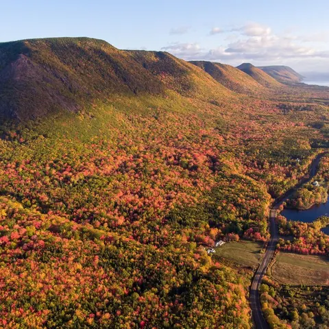 Aerial view of autumn-coloured highlands and a river valley along the Cabot Trail
