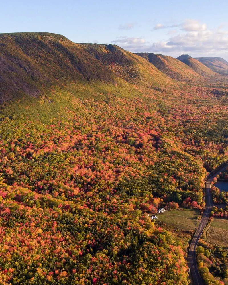 The Cabot Trail winding along the coast through autumn-coloured highlands