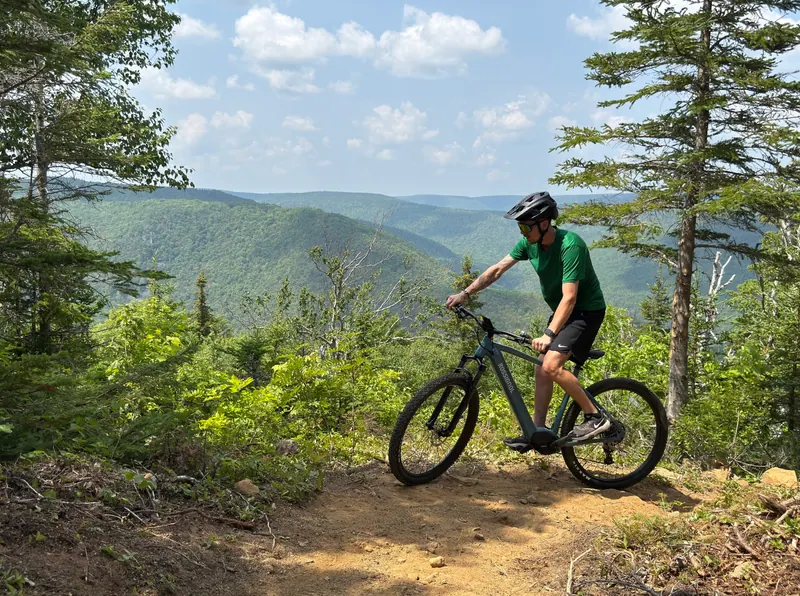 Mountain biker riding a forest trail above the Cape Breton Highlands