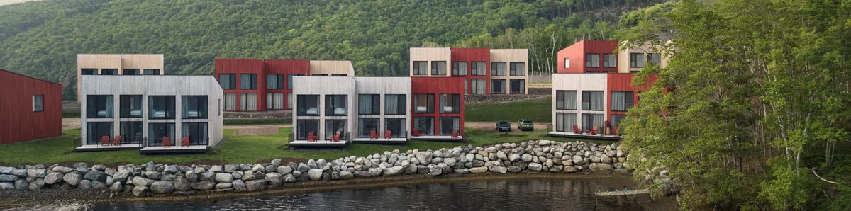 Cormorant Rock chalets on the waterfront below forested hills