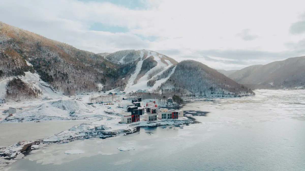 Winter aerial view of the chalets on the snowy shore beneath the Cape Smokey ski runs