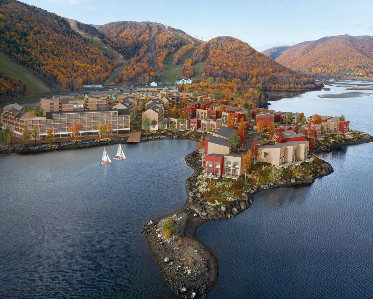 Chalets among trees in autumn colours above the bay