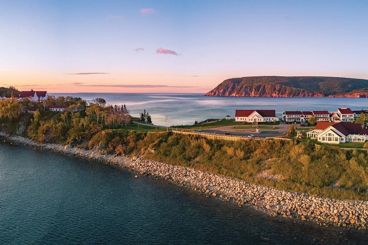 Lodge buildings on a rocky coastal headland at sunset