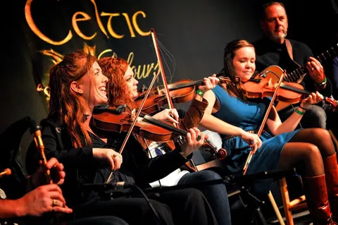 Fiddlers playing Celtic music on stage