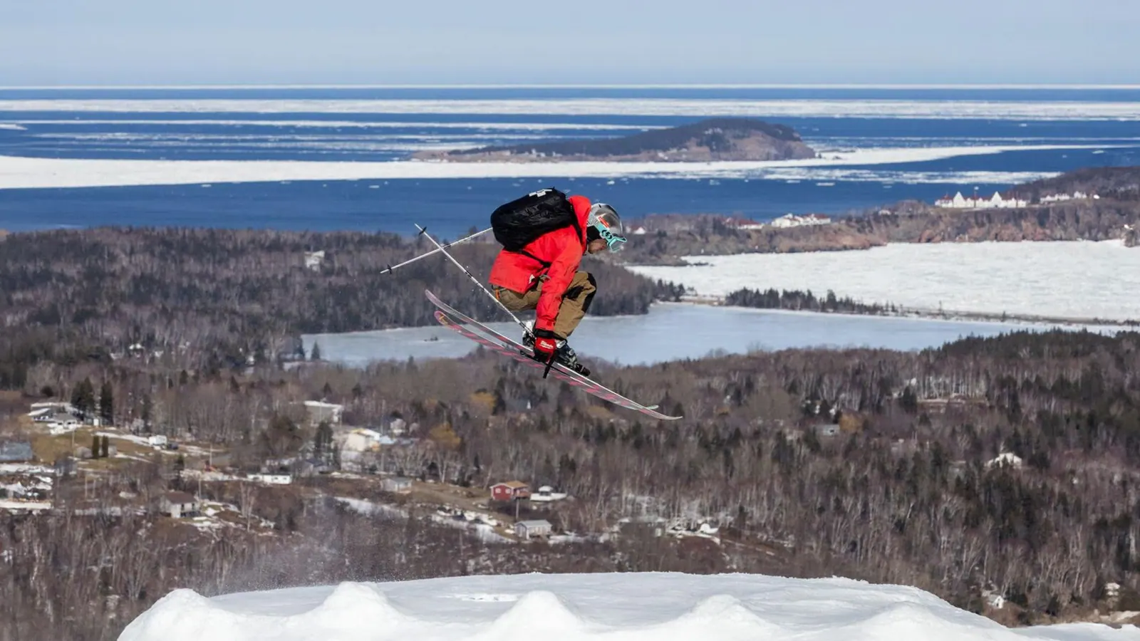 Skier in the air above a groomed run at Cape Smokey