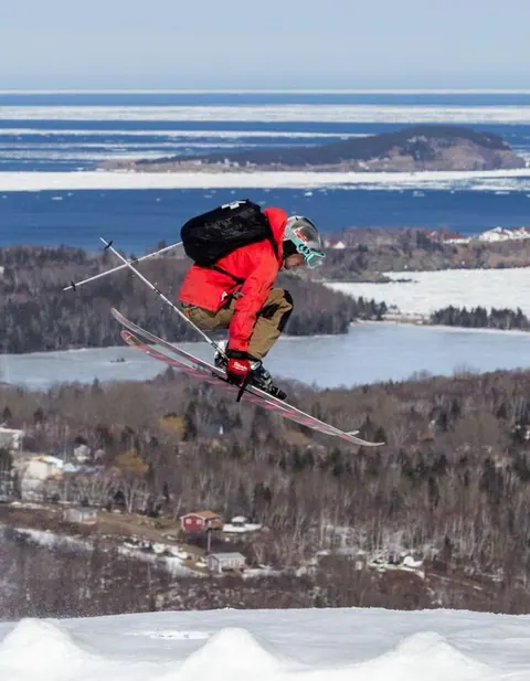 Skier in the air above a groomed run at Cape Smokey