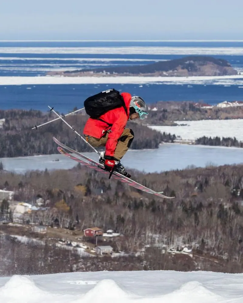Skier in the air above a groomed run at Cape Smokey
