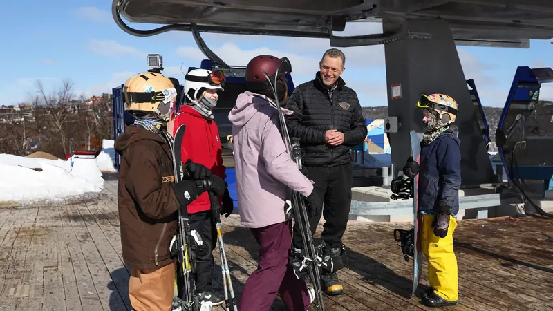 Skiers in helmets chatting at the Cape Smokey gondola
