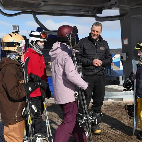 Skiers in helmets chatting at the Cape Smokey gondola