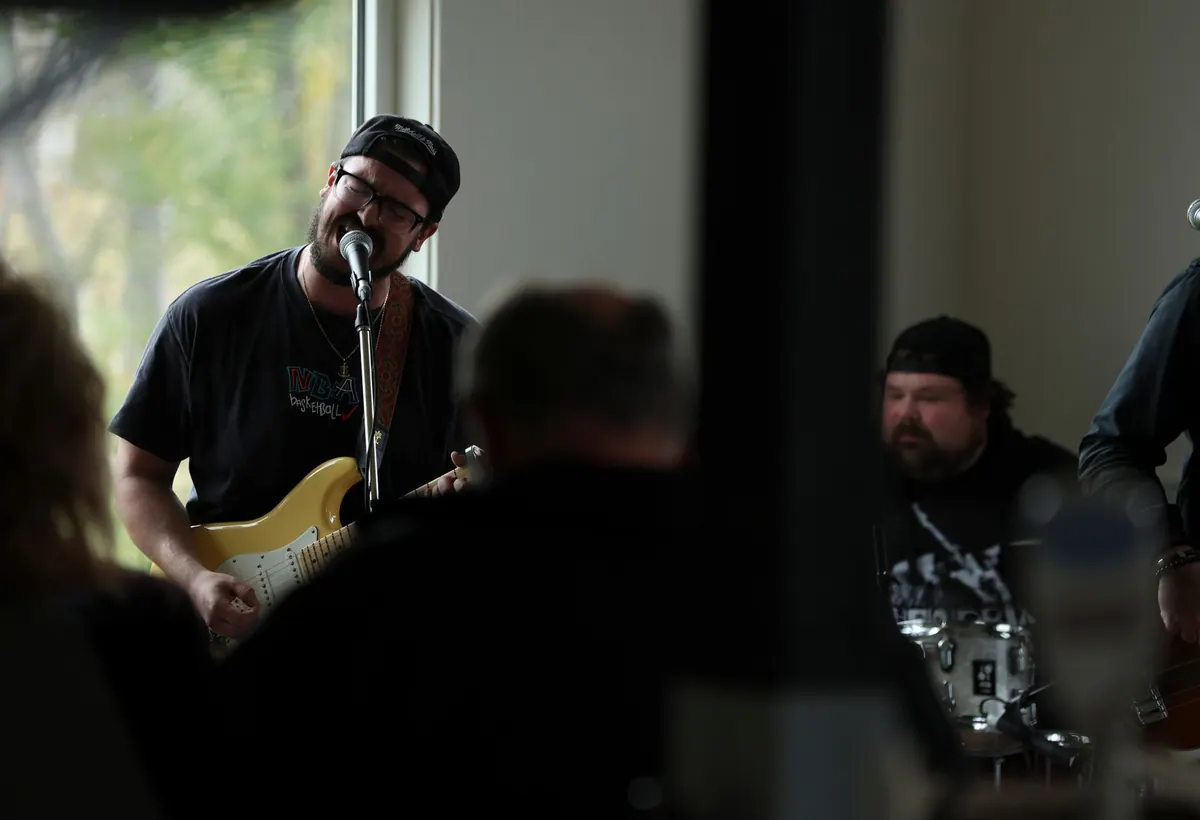 Musician singing and playing guitar at an indoor concert