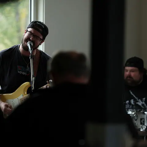Musician singing and playing guitar at an indoor concert