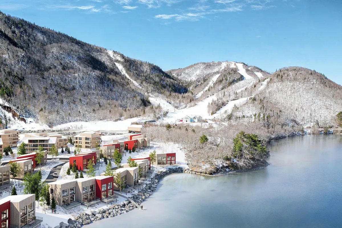 Chalets under snow beside the frozen shore
