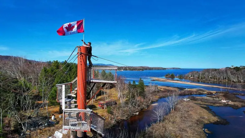 Zipline launch tower with a Canadian flag above the coast