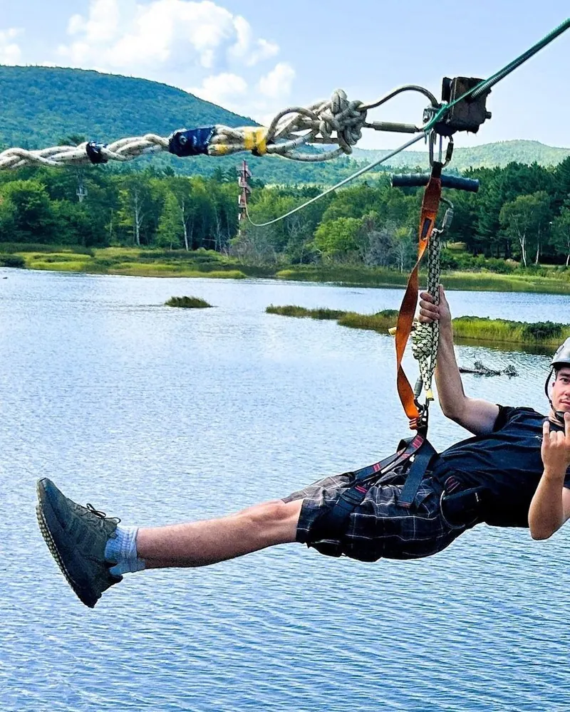 Zipline rider above the treetops of Cape Breton